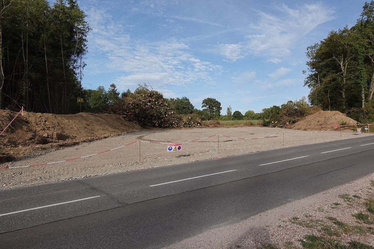 Un terrain défriché et décapé pour l’A412 à Loisin, au bord de la départementale : rubalise, tas de terre et de grumes
