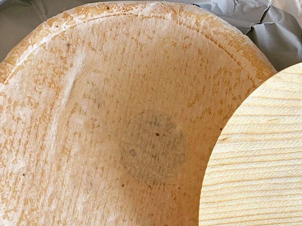 Un reblochon coupé en deux, sur une ardoise